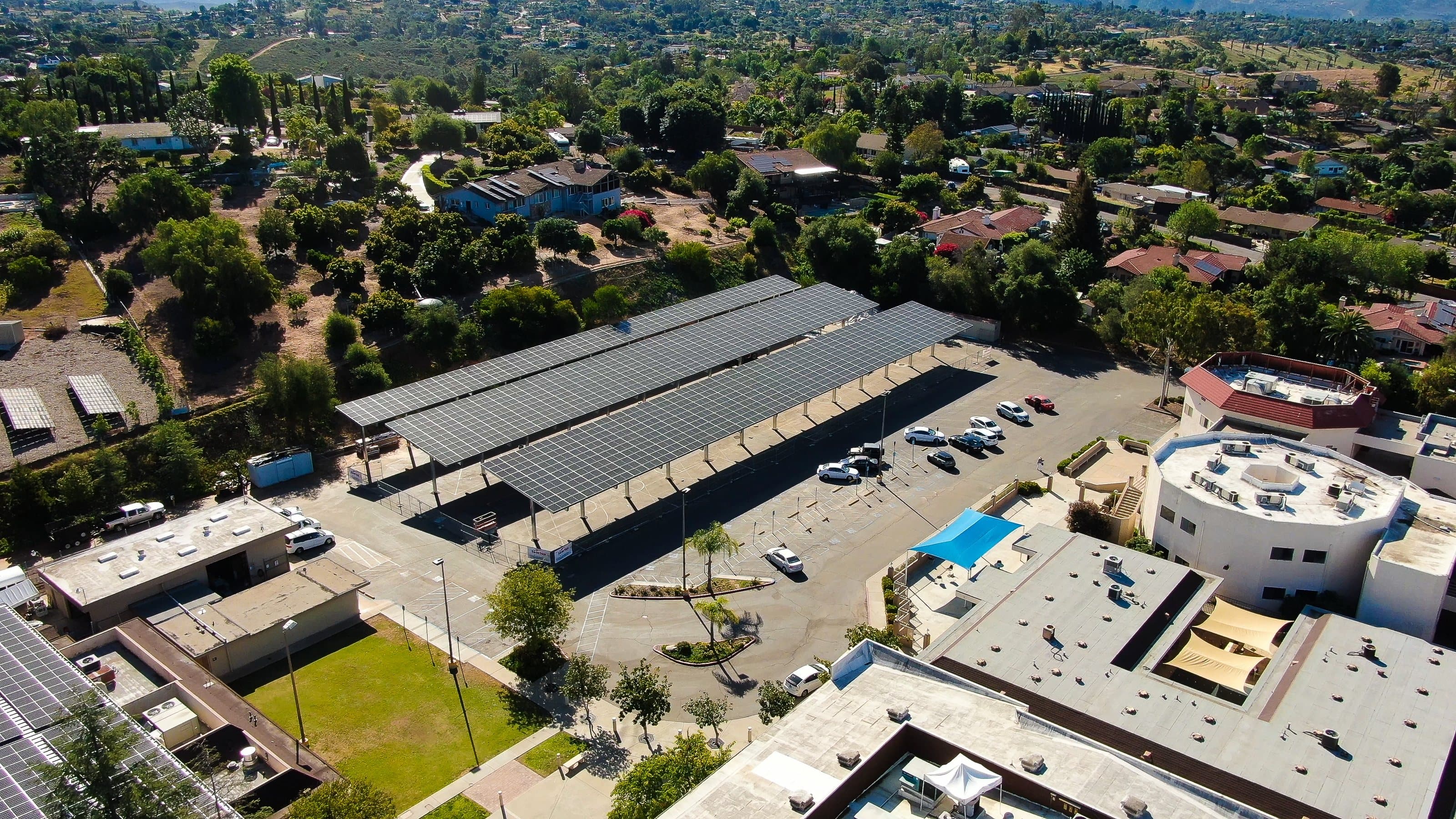 Aerial view of solar canopy rows across a large commercial parking lot