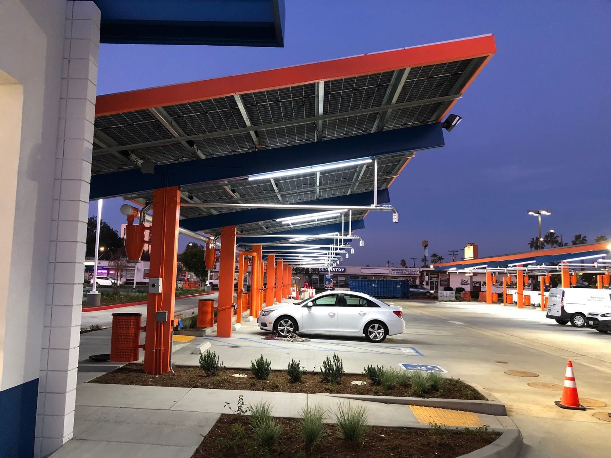 Branded canopy with under-lighting over a dealership forecourt at night