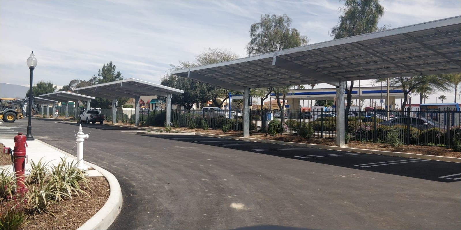 Street view of a solar carport canopy at the edge of a commercial lot