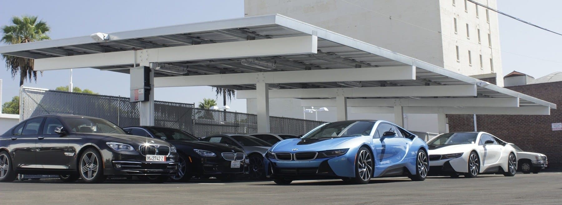 Wide view under a solar canopy with vehicles parked in a row
