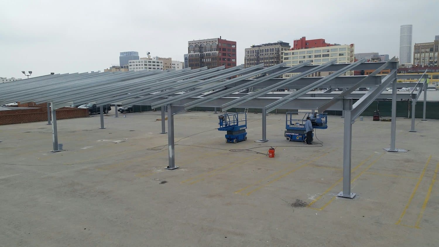 Solar carport frames being installed on the roof deck of a building