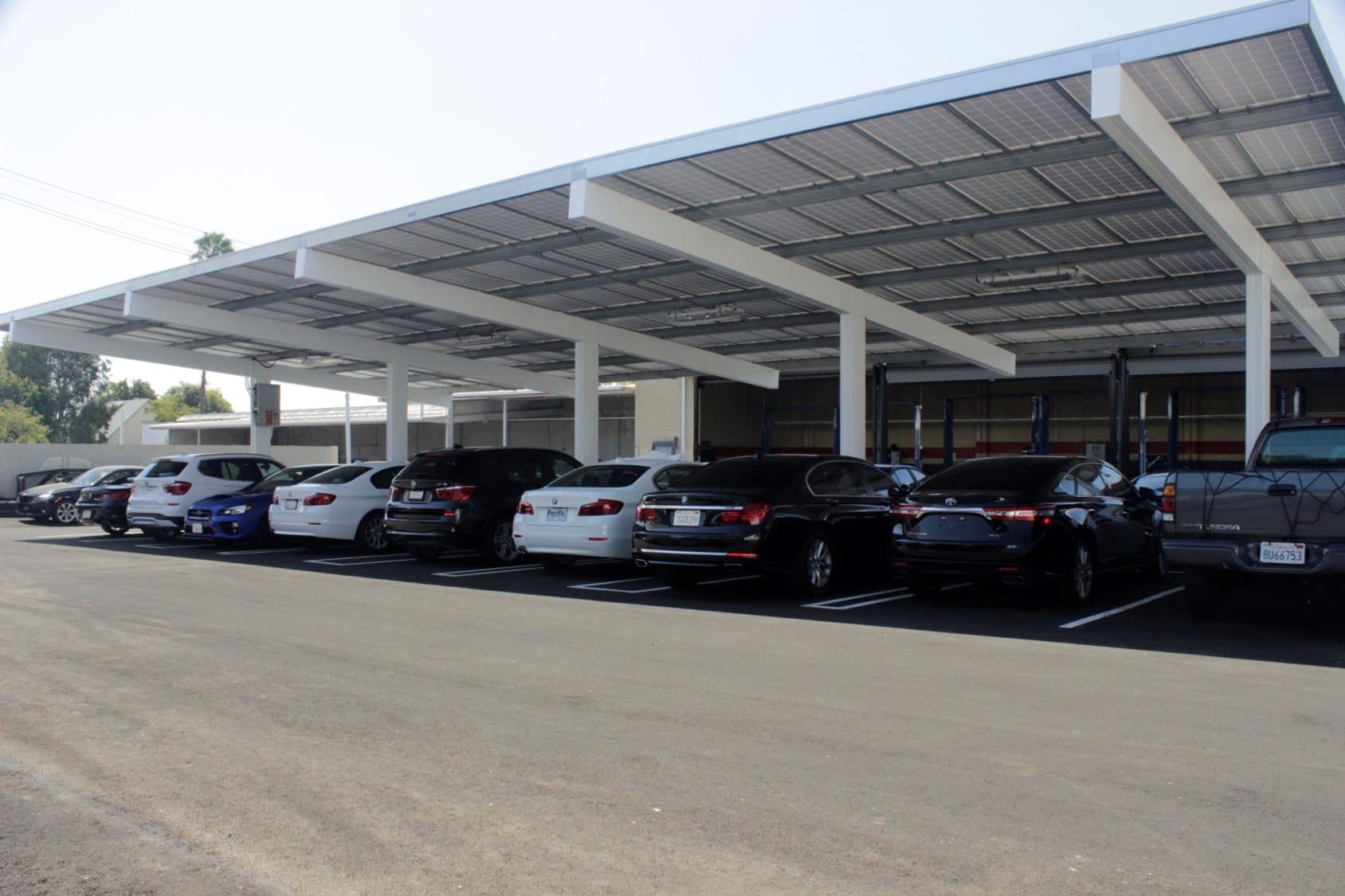 View from under a solar canopy with cars parked in the shade