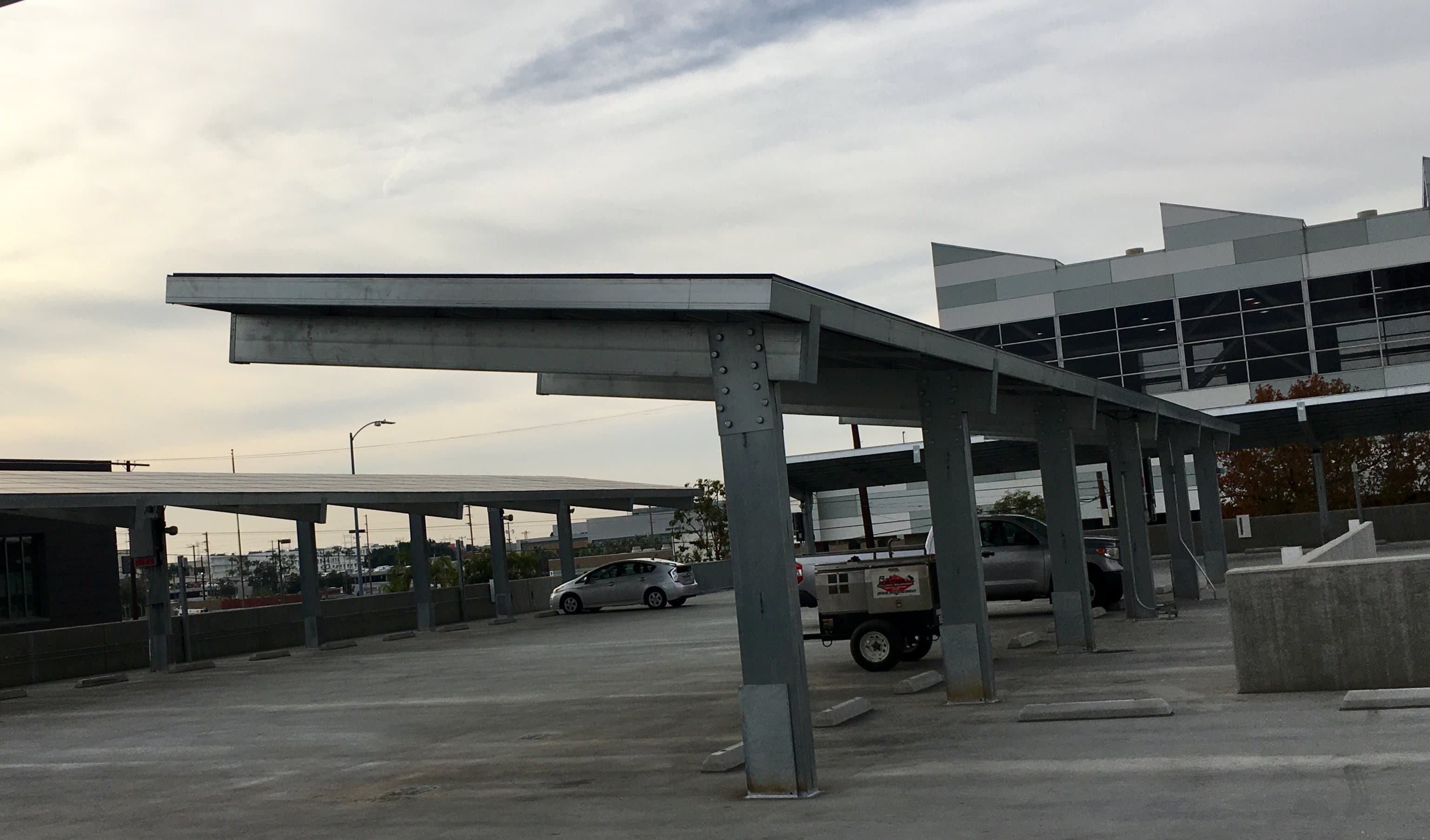 T-cantilever solar carport on the top deck of a parking structure at dusk